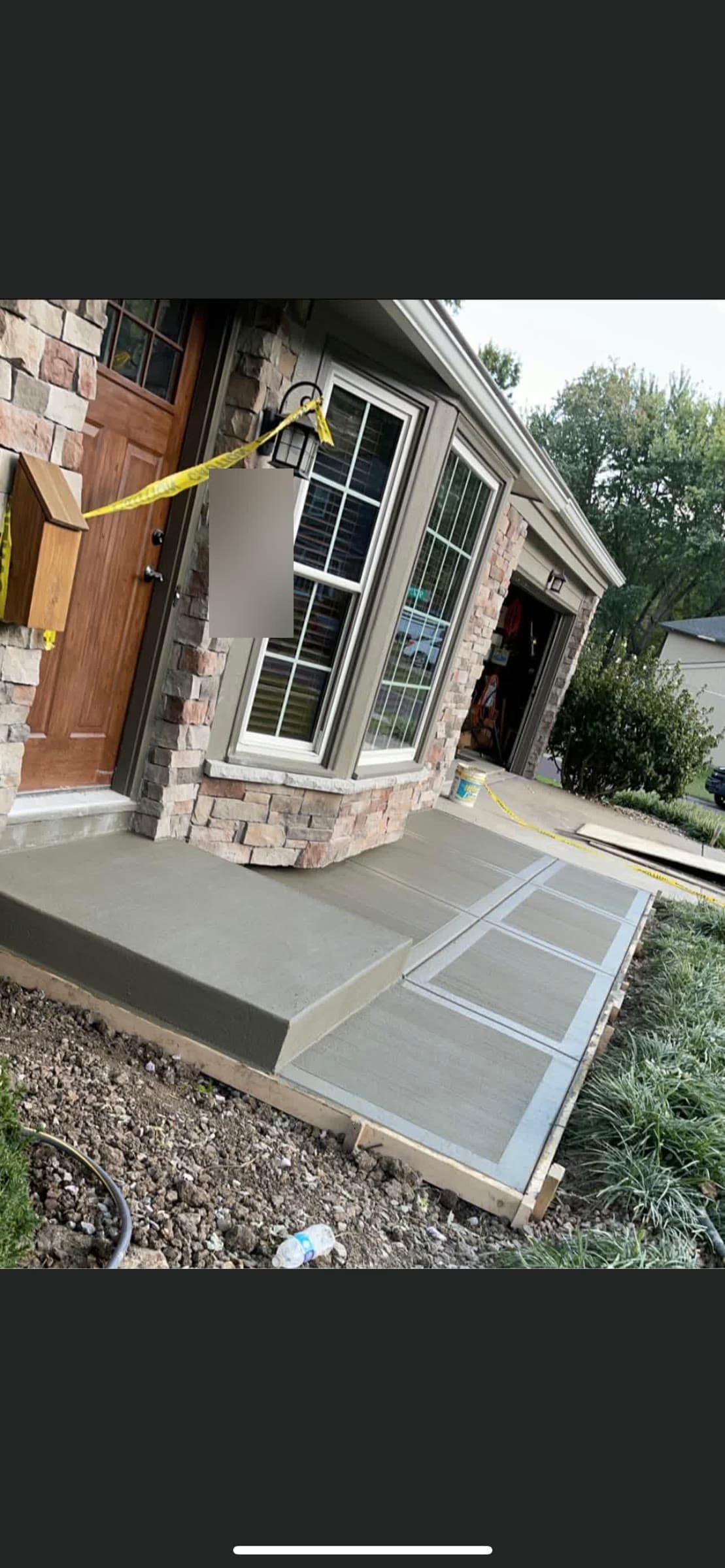 New concrete entry stoop and connecting walkway at a stone-and-brick home