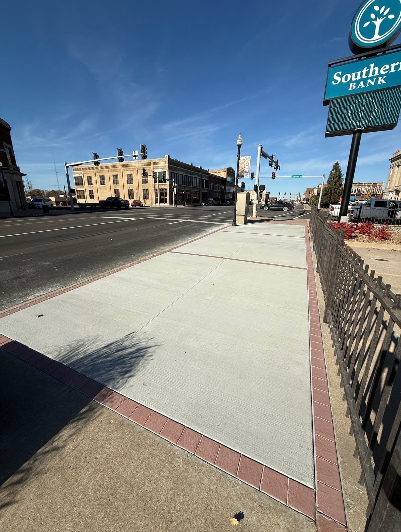 New brick-bordered commercial concrete sidewalk on a downtown corner outside a Southern Bank branch