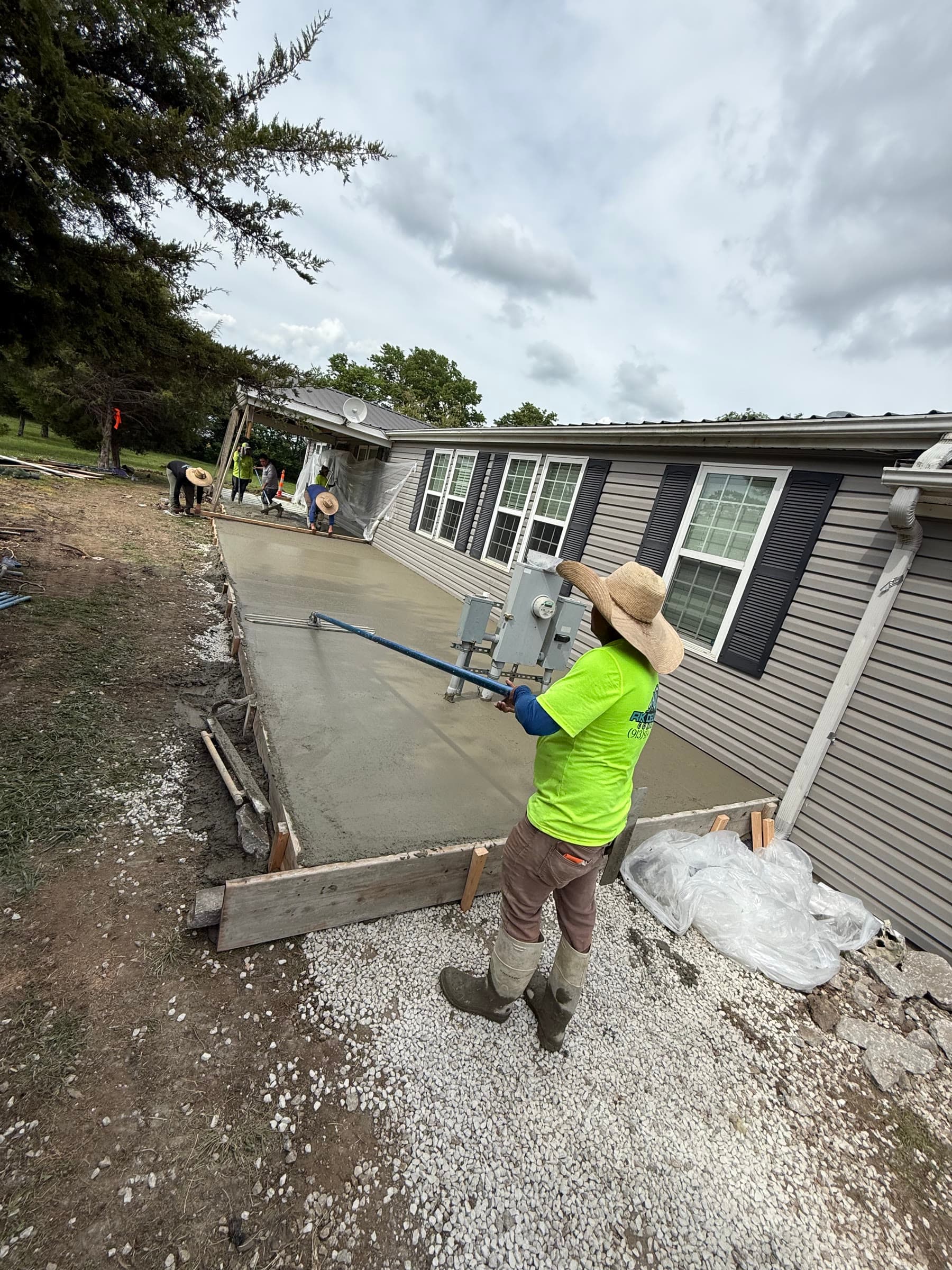 RK Deluxe Concrete crew member hand-finishing a freshly poured concrete slab