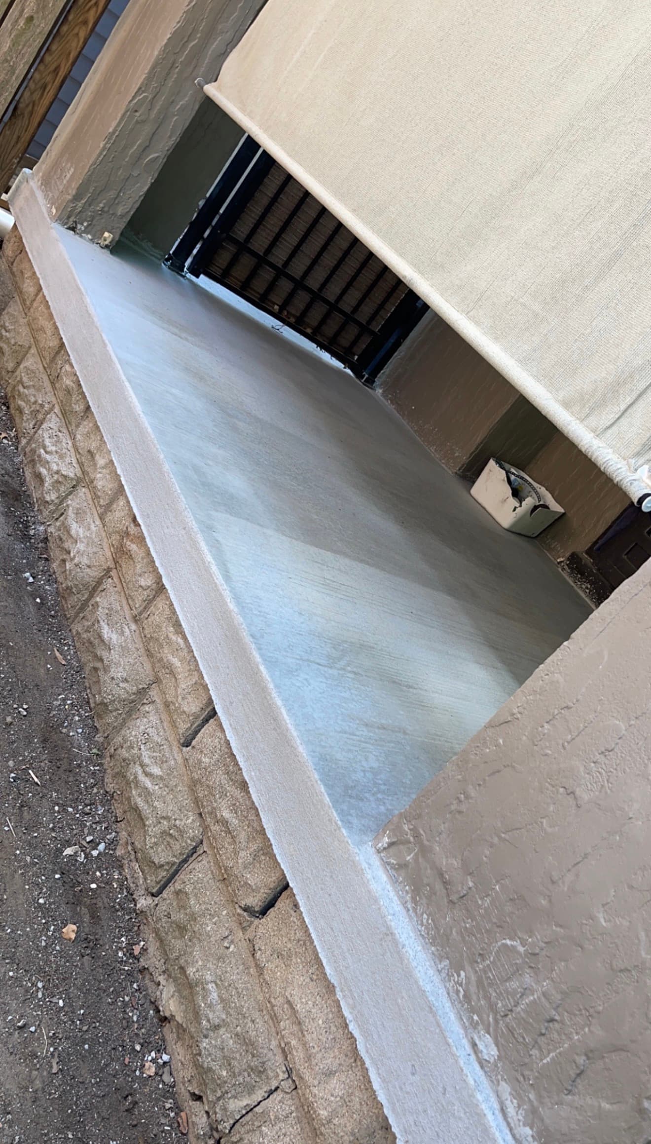 Finished concrete stoop with a smooth troweled surface, sealed and finished against the existing house structure