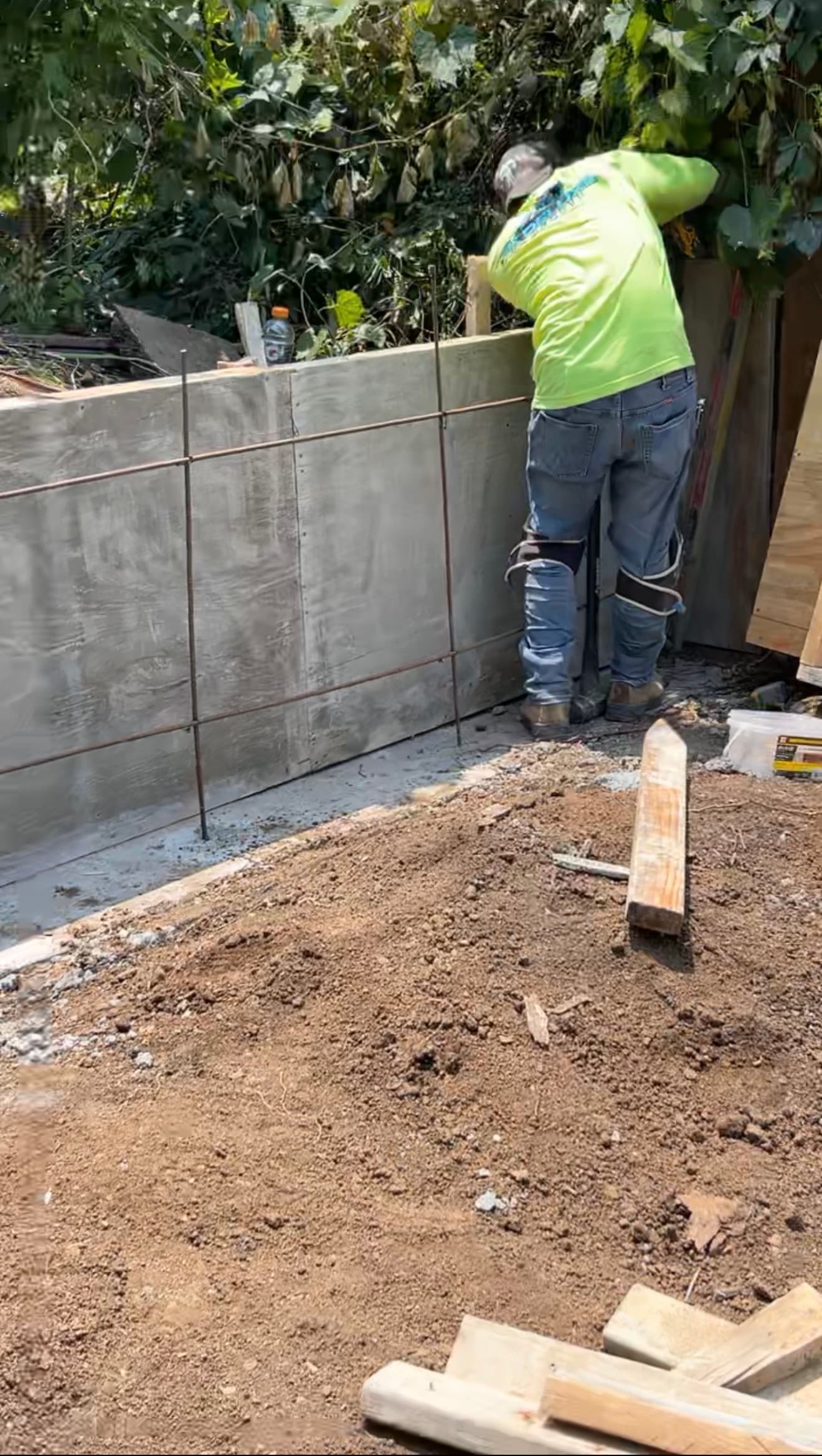 Retaining wall formwork and reinforcing steel being assembled, before concrete placement