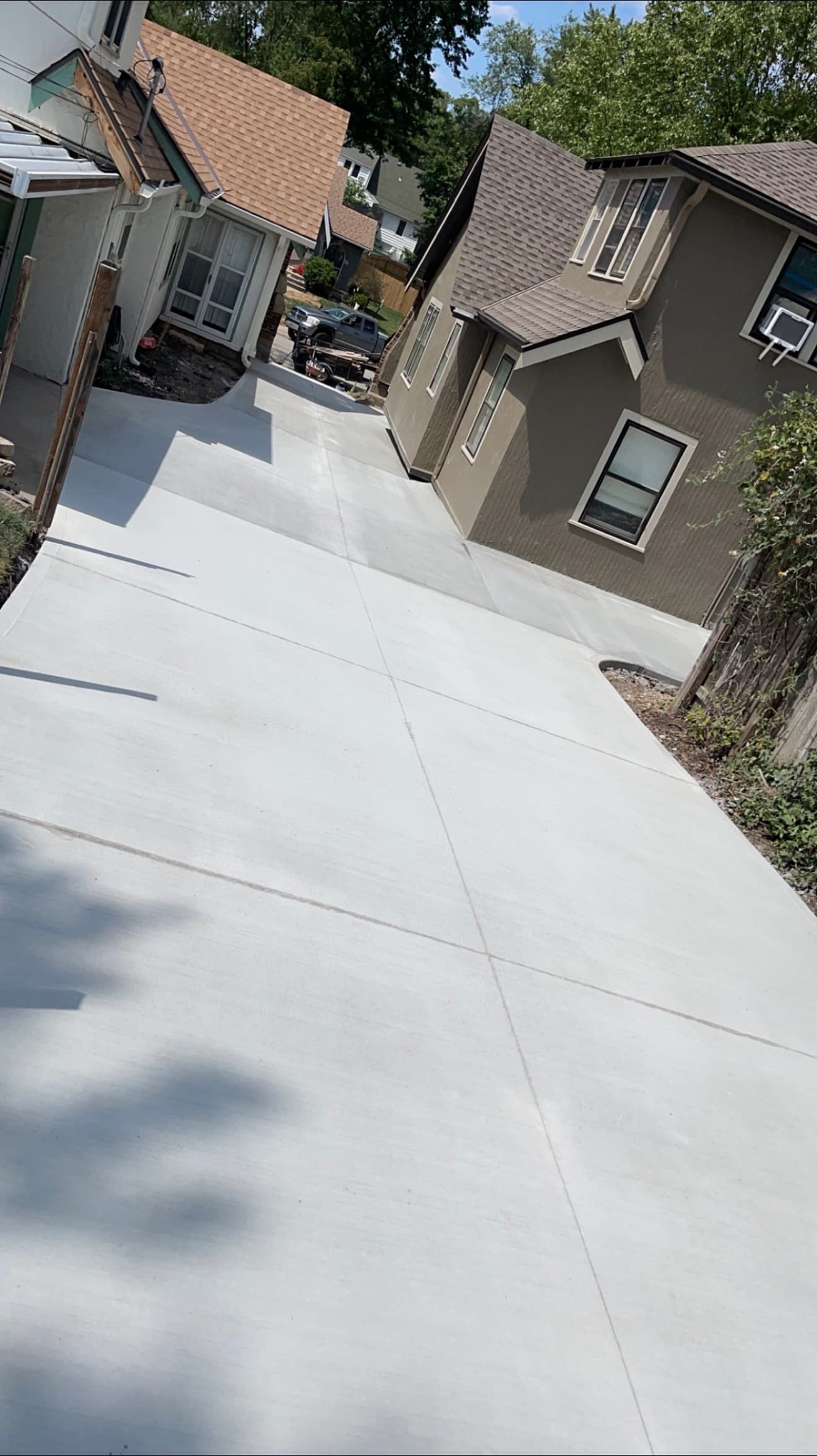 Finished shared concrete driveway running the full length of the corridor between two houses